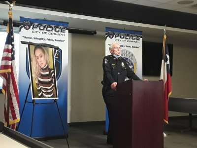 Chief Garner speaking about the investigation with image of Amanda Clairmont visible in the background.